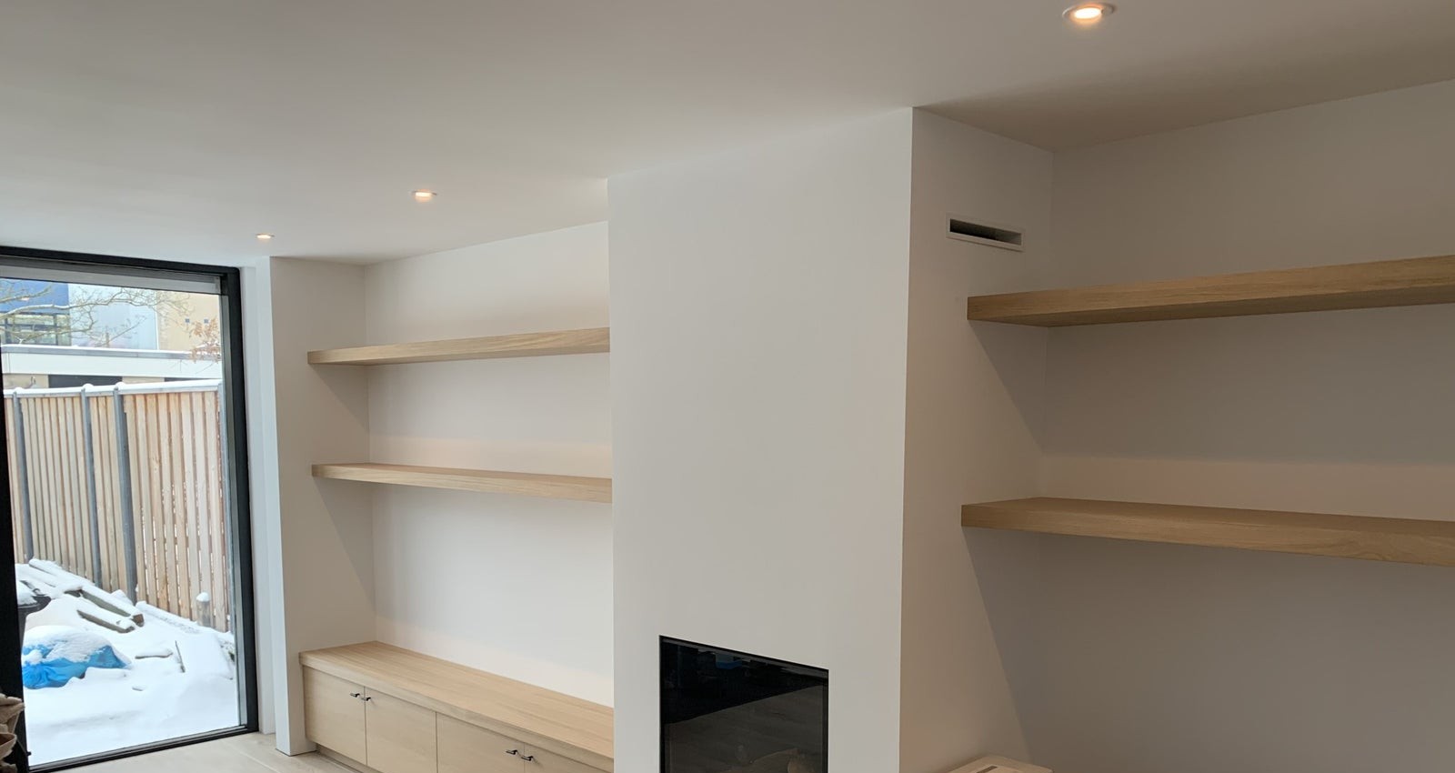 Gestucte haardwand met eiken wandplanken